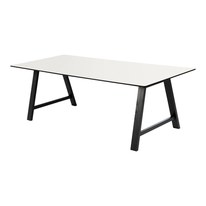 Modern rectangular table with a sleek white top and contrasting black legs, featuring a minimalist design.