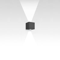 Black cube wall light with sleek, modern design; emits two beams of light creating a geometric pattern against a white background.
