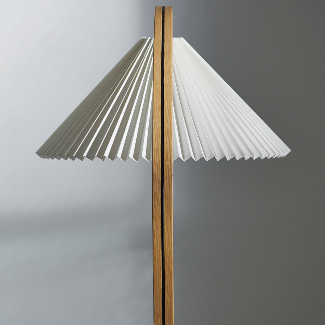 White pleated lampshade with natural wood accents, creating a modern and elegant contrast in colors and textures.