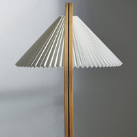 White pleated lampshade with natural wood accents, creating a modern and elegant contrast in colors and textures.