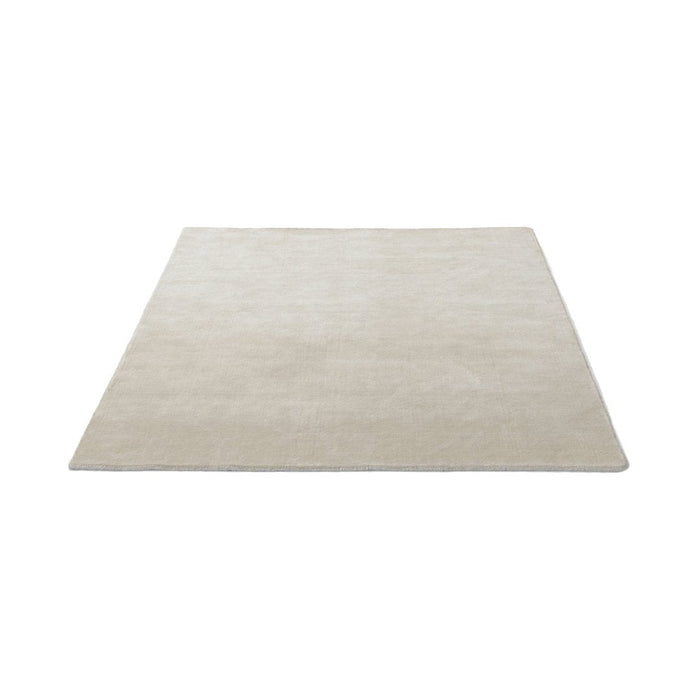 Beige, solid-pattern rug with a smooth texture, perfect for enhancing any home decor.