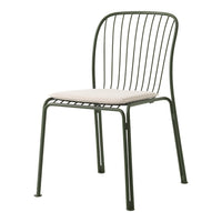 Green metal dining chair with sleek wire design and light beige cushion. Modern, minimalist style for any space.