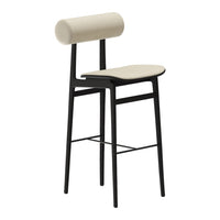 Modern beige bar stool with a cylindrical backrest and sleek black metal legs, showcasing a minimalist design.