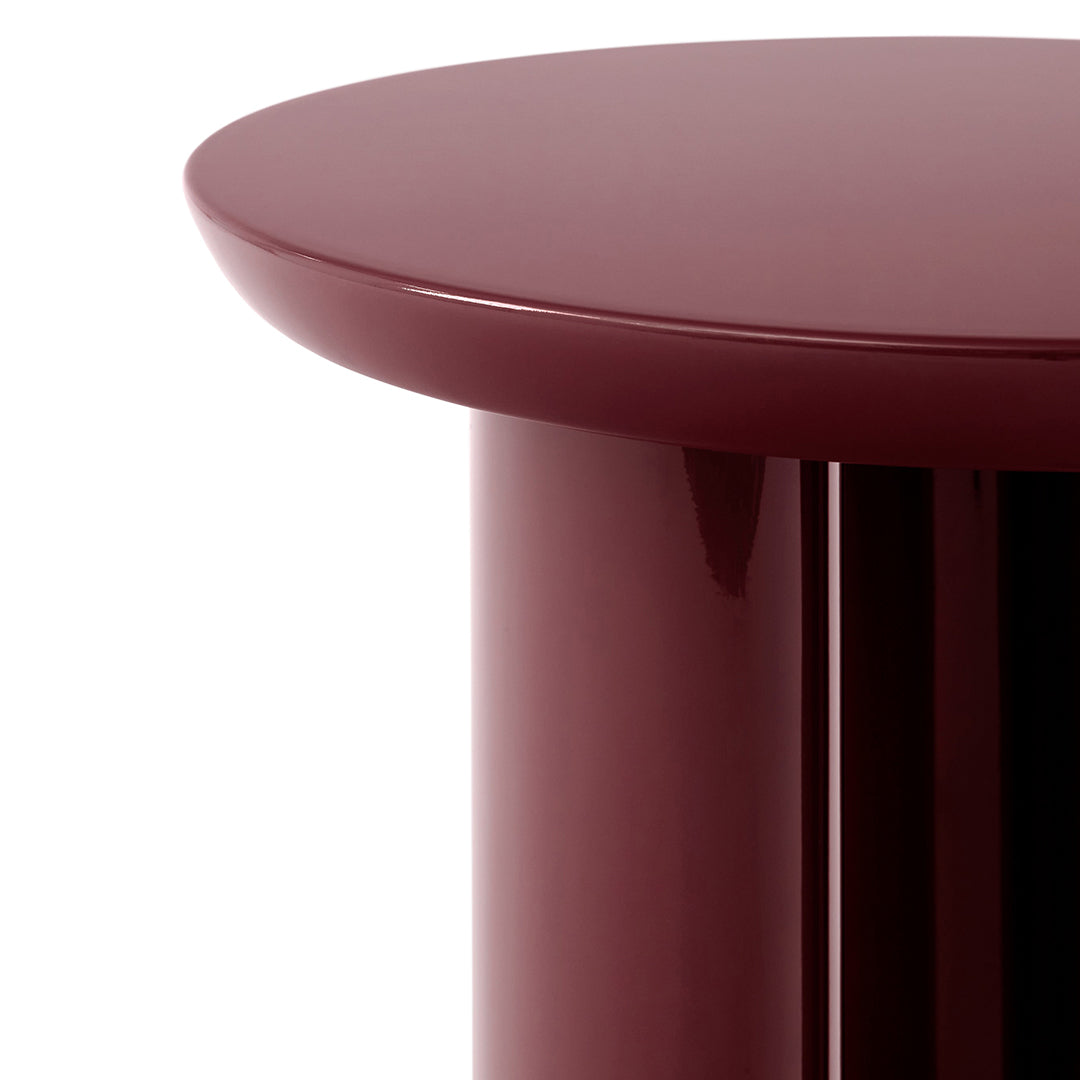 Glossy burgundy round tabletop with a sleek cylindrical base, perfect for modern decor.