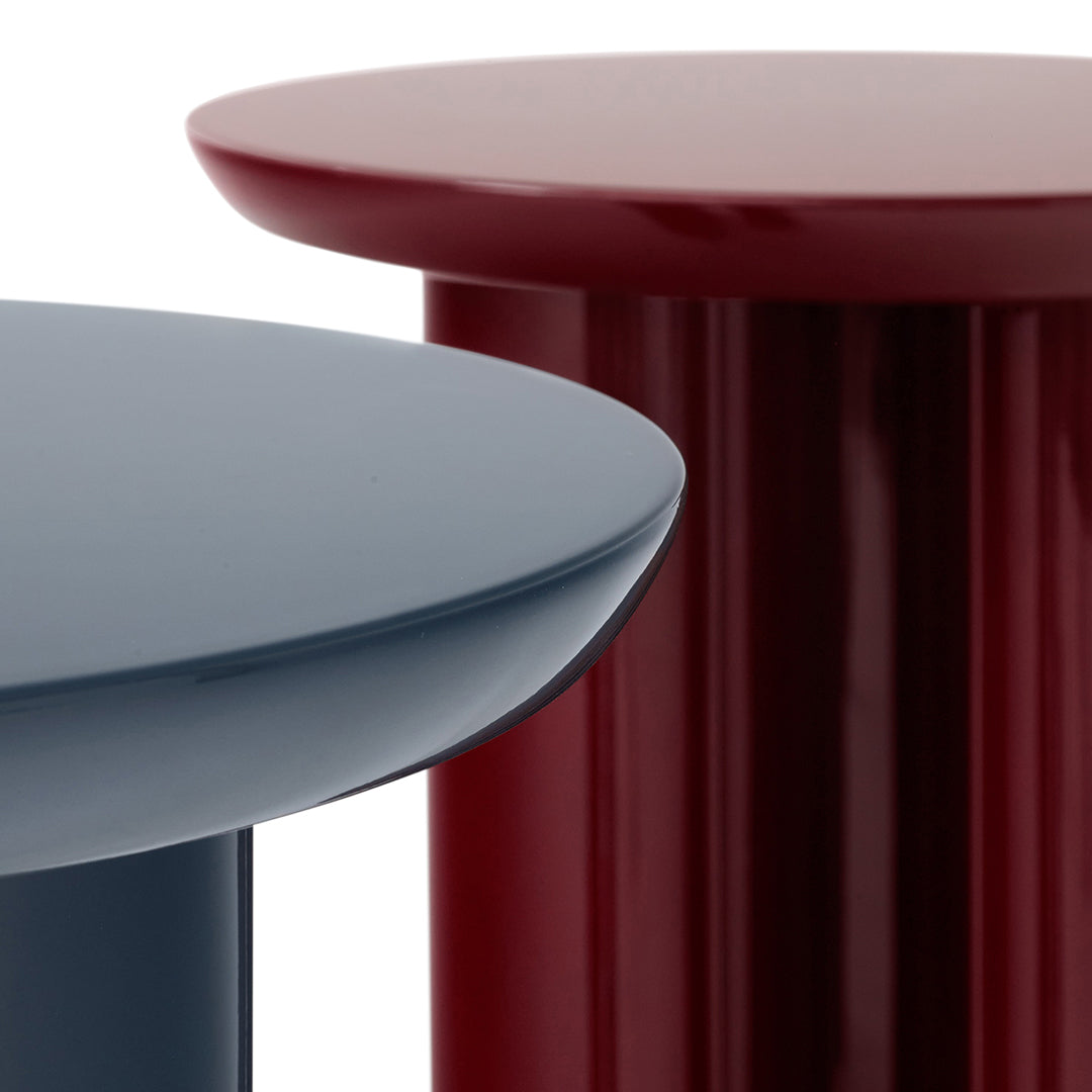 Two modern side tables in navy blue and deep burgundy, showcasing sleek, glossy finishes and minimalist design.