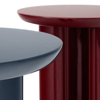 Two modern side tables in navy blue and deep burgundy, showcasing sleek, glossy finishes and minimalist design.