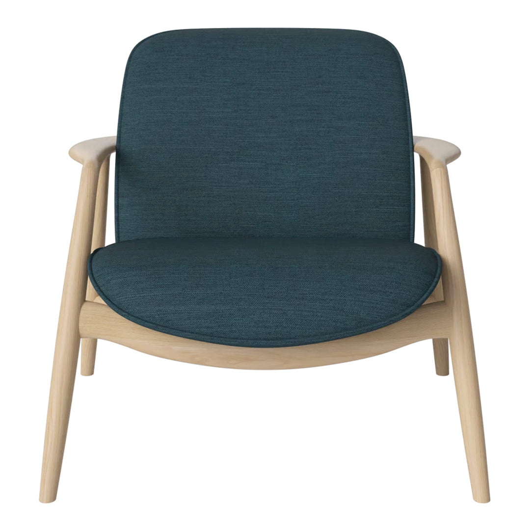 Teal upholstered chair with a smooth texture and light wood frame, ideal for modern interiors.
