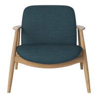 Teal upholstered chair with a smooth texture and light wood legs, showcasing modern minimalist design.
