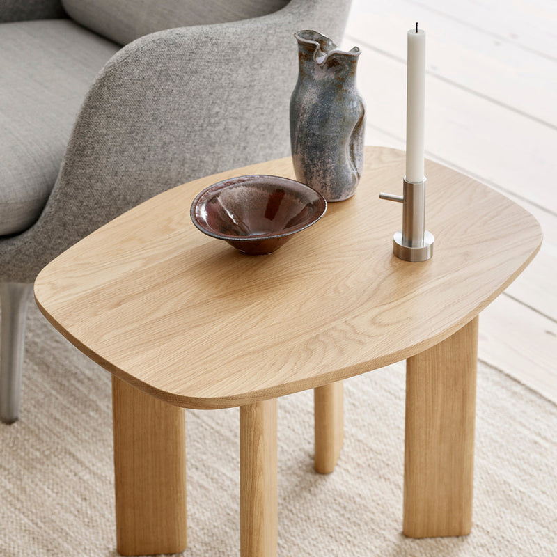 Natural oak wood table with a smooth, rounded edge, showcasing a minimalist design and earthy tones.