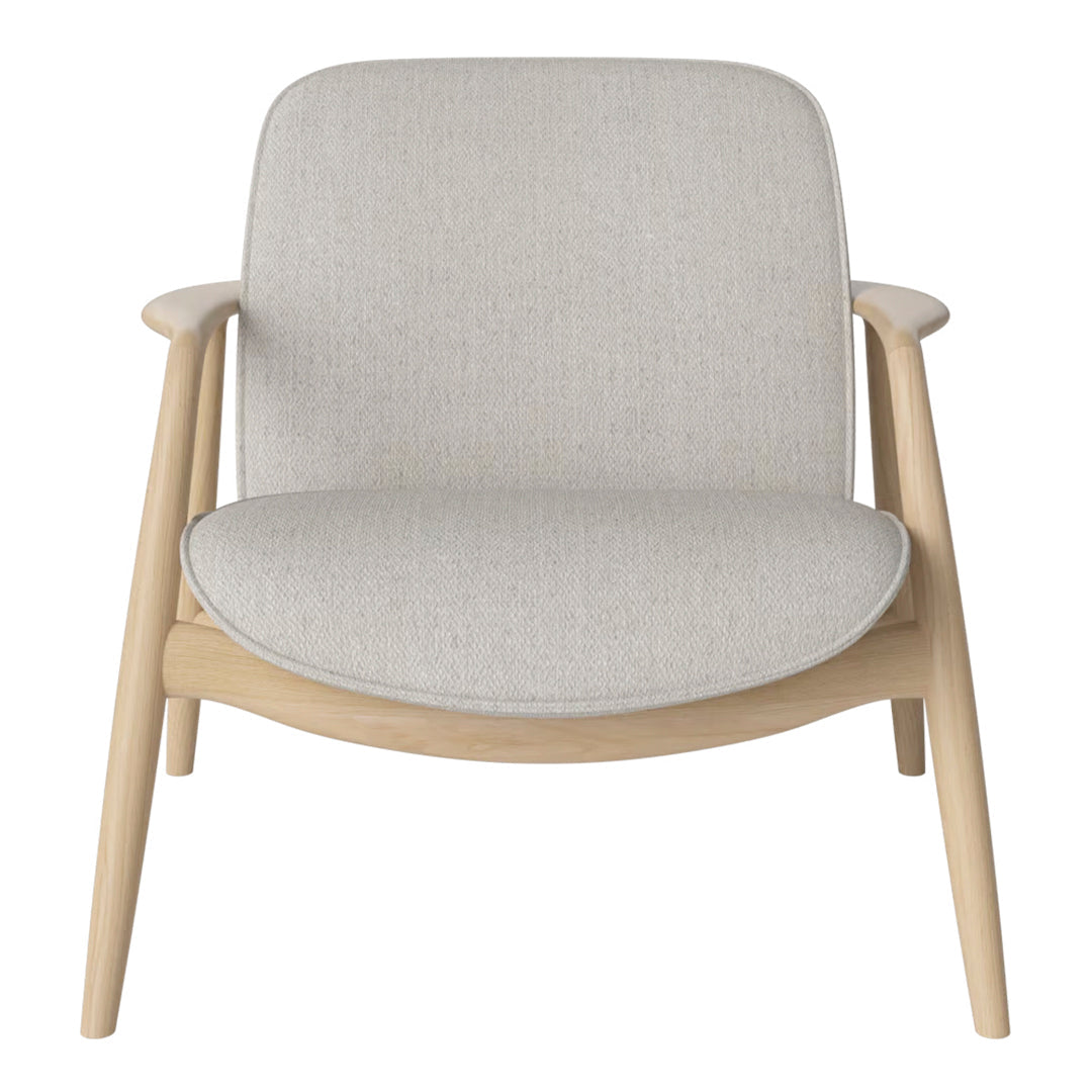 Light gray upholstered lounge chair with minimalist design and natural wood frame, featuring smooth, neutral tones.