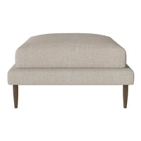 Neutral beige upholstered ottoman with a smooth texture and tapered wooden legs, perfect for modern decor.