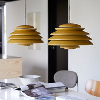 Two layered pendant lights in vibrant mustard yellow, creating a modern and stylish pattern in a contemporary setting.