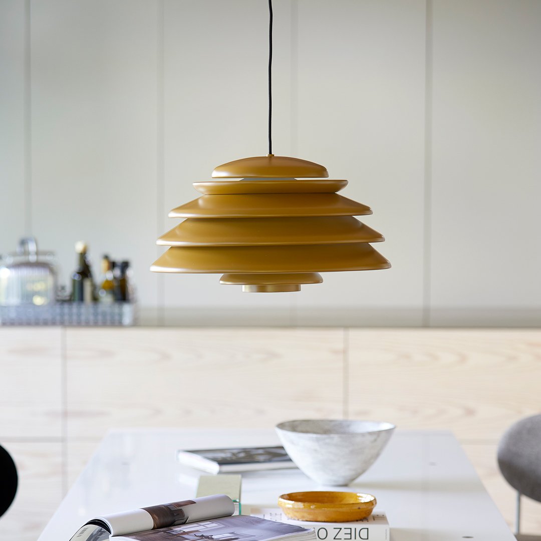 Yellow layered pendant lamp with a smooth finish, set against a minimalist, neutral backdrop. Perfect for modern decor.