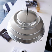 Sleek metal pendant lamp with a brushed silver finish and layered circular design. Perfect for modern decor.