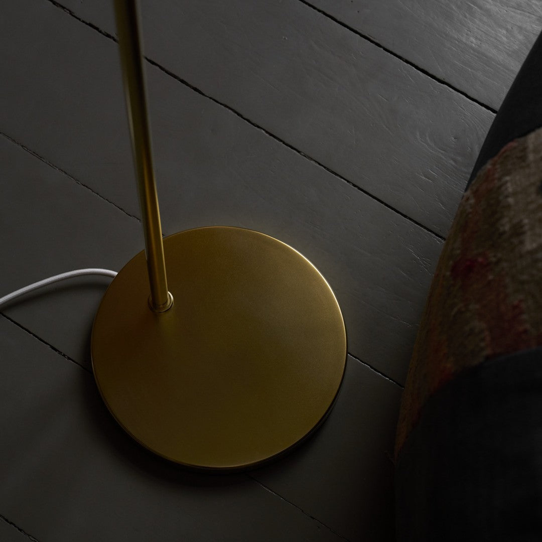 Gold floor lamp base on a dark wooden floor