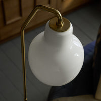 White lampshade with gold arm on a blurred background