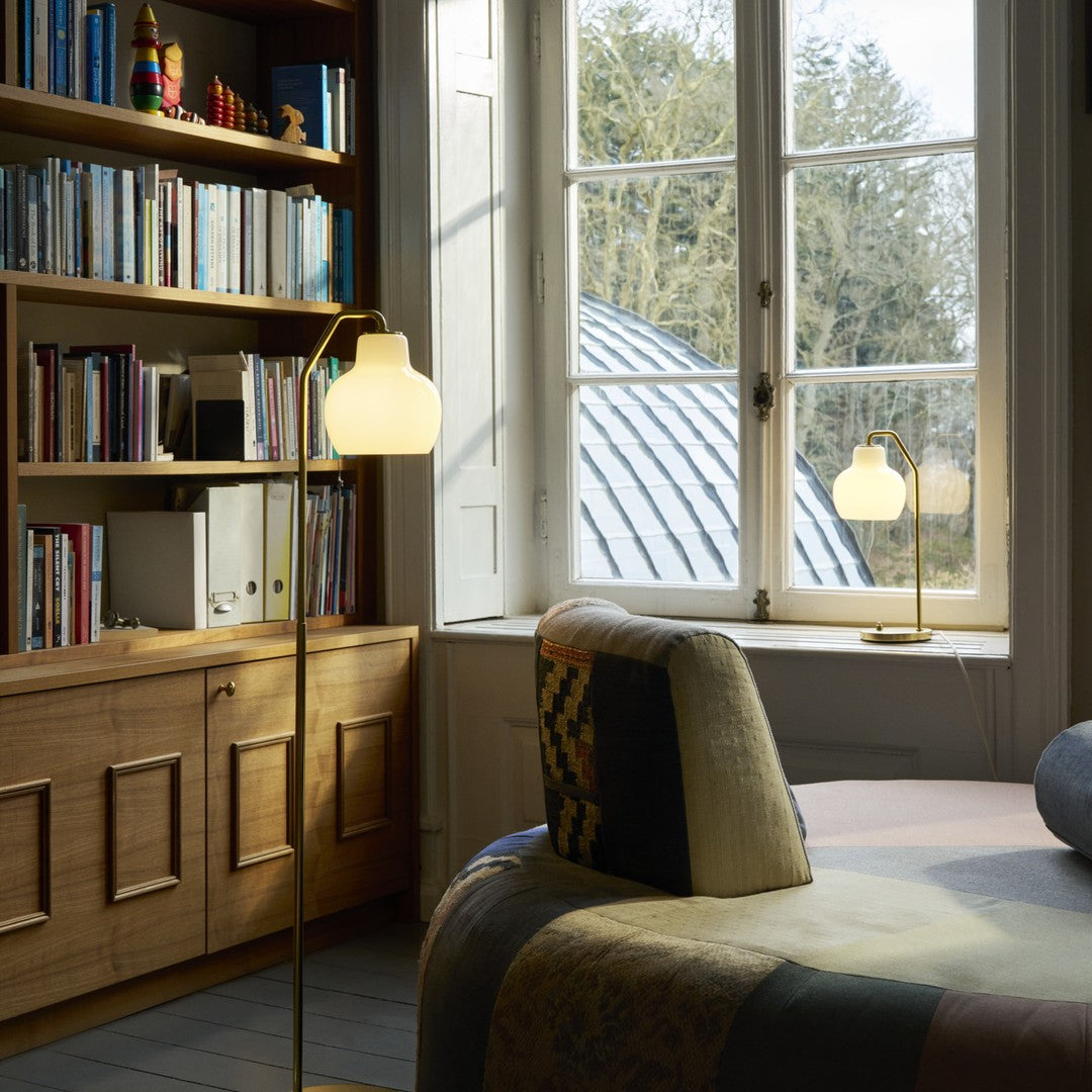 Cozy room with a bookshelf, lamp, and window view