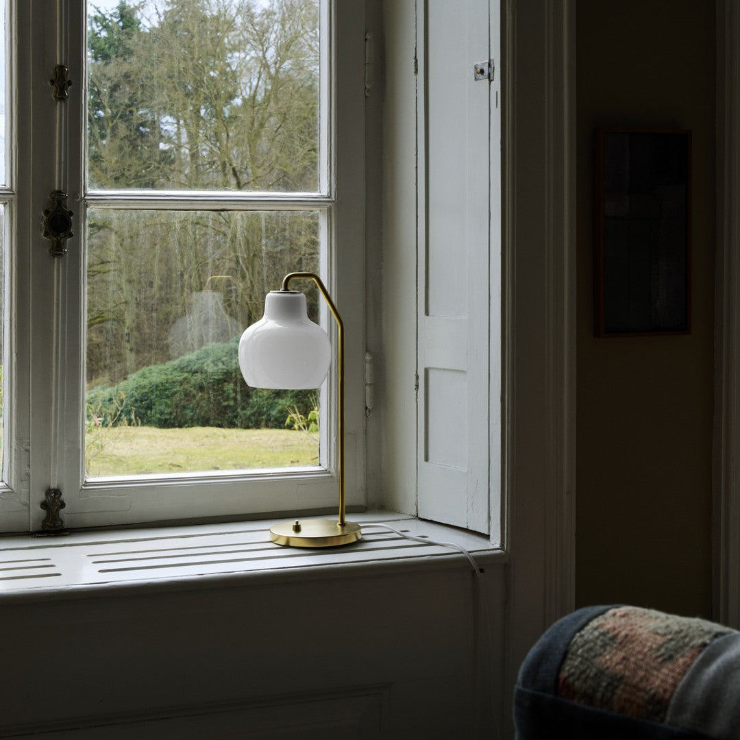 Table lamp with white glass shade on a windowsill
