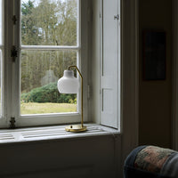 Table lamp with white glass shade on a windowsill