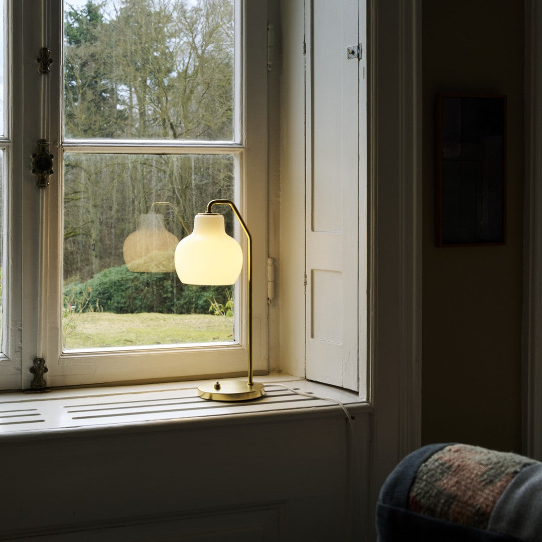 Lamp on a windowsill with a view of trees outside