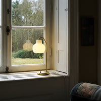 Lamp on a windowsill with a view of trees outside