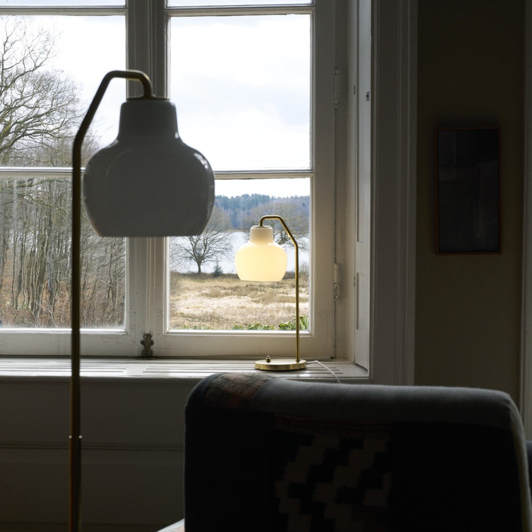 Lamps in a room with a window view of trees and fields