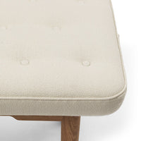 Cream-colored tufted cushion with a textured pattern on a natural wood base. Perfect for modern home decor.