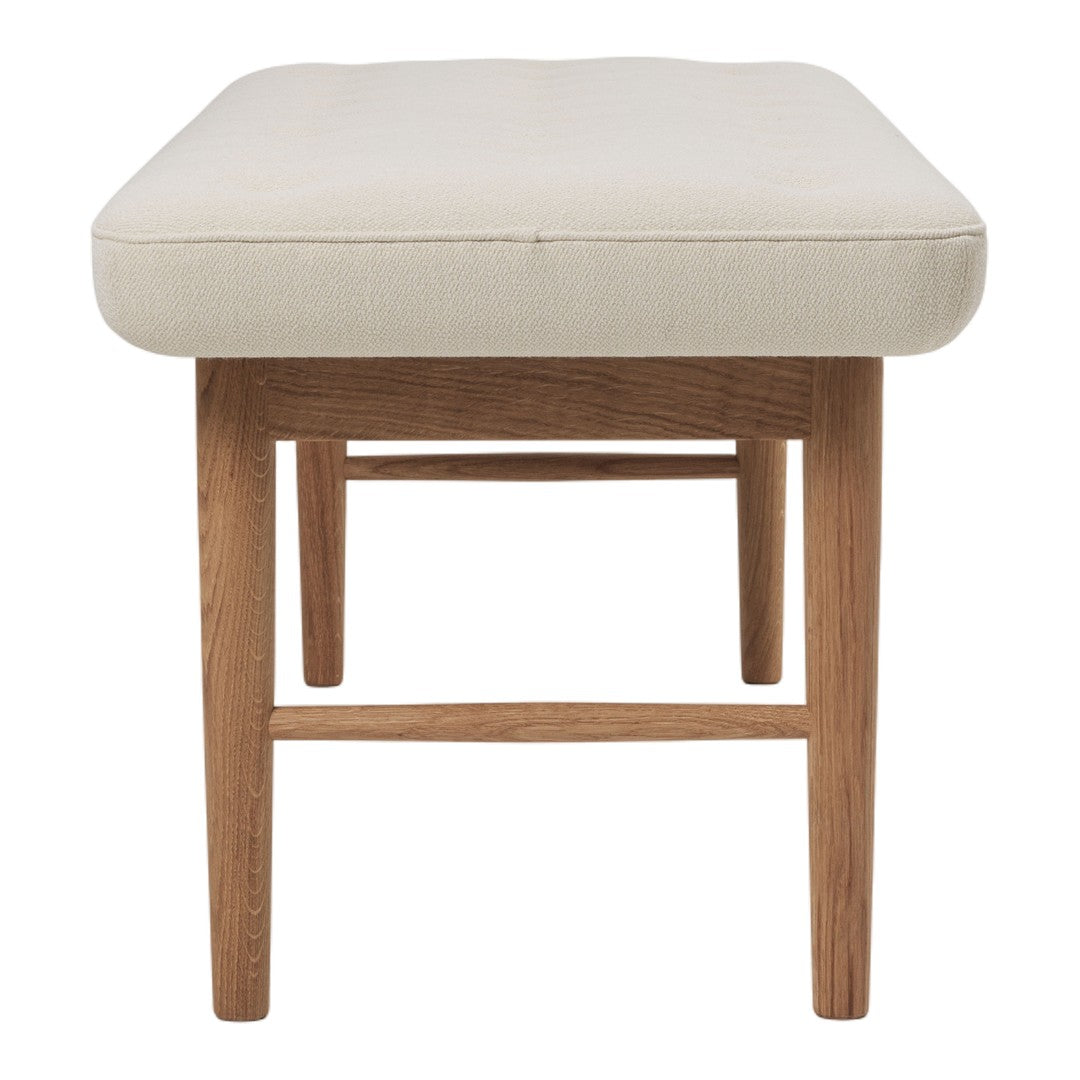 Neutral cream cushion with a smooth texture, supported by light wooden legs, creating a modern, minimalist look.