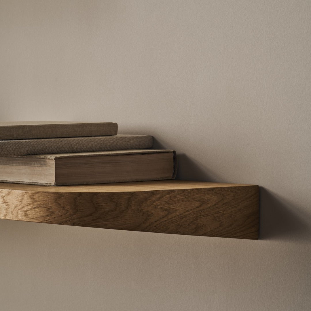 Wooden shelves in warm tones of beige and brown, featuring a smooth, natural wood grain pattern against a neutral wall.