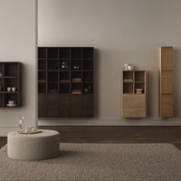 Modern wooden furniture in dark and light tones with minimalist design on a neutral gray wall backdrop.