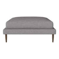 Gray upholstered ottoman with a sleek, modern design and wooden legs, perfect for contemporary home decor.