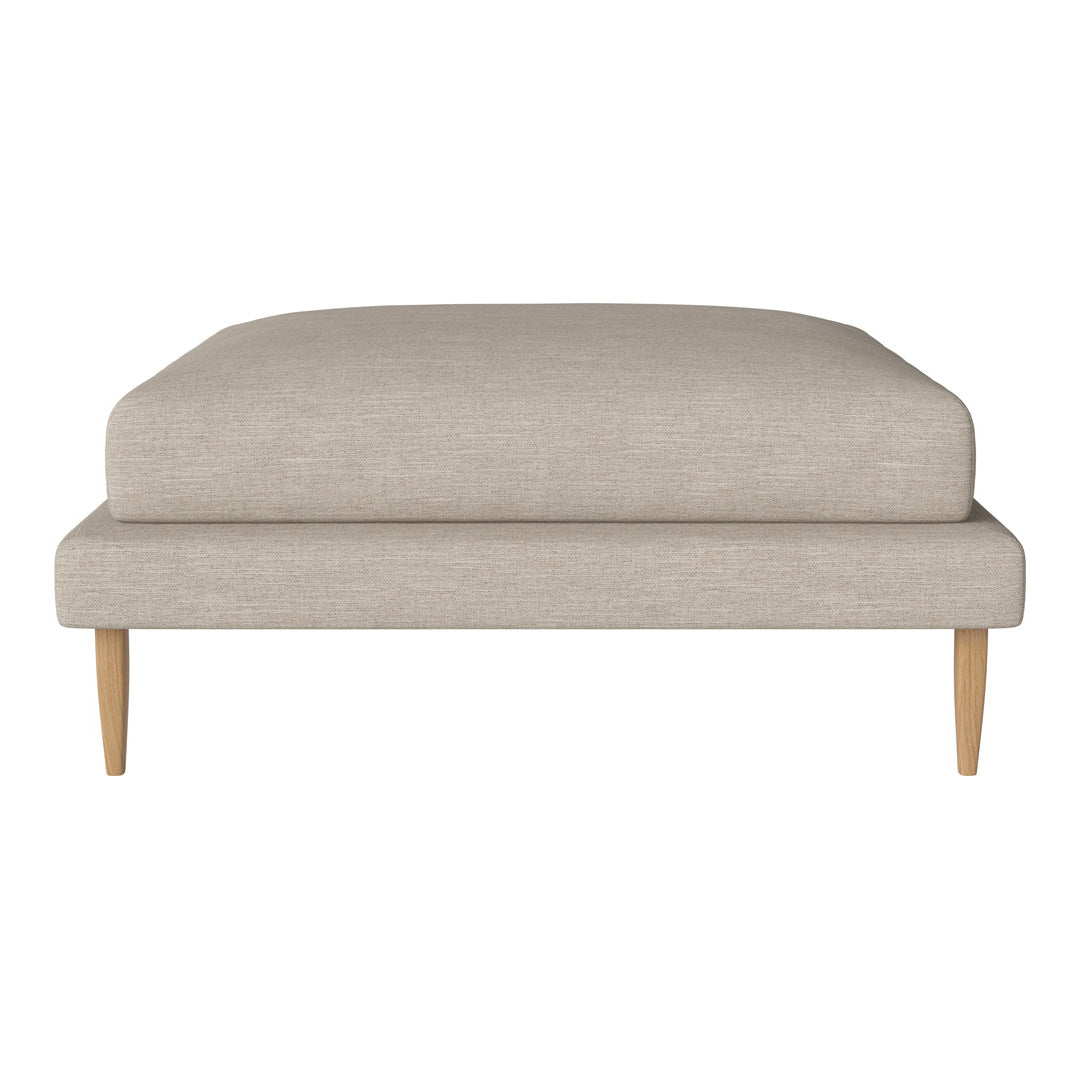 Beige upholstered ottoman with minimalist design and light wooden legs, perfect for modern décor.