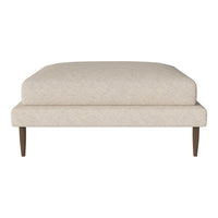 Beige upholstered ottoman with a clean, minimalist design and tapered wooden legs. Suitable for modern decor.