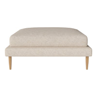 Beige upholstered ottoman with a subtle textured pattern and light wood legs. Stylish and modern design for any decor.