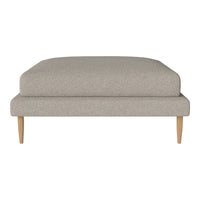 Light beige upholstered ottoman with a smooth, textured finish and natural wooden legs. Simple and modern design.