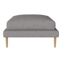 Gray upholstered ottoman with a smooth finish and natural wooden legs, perfect for modern decor.
