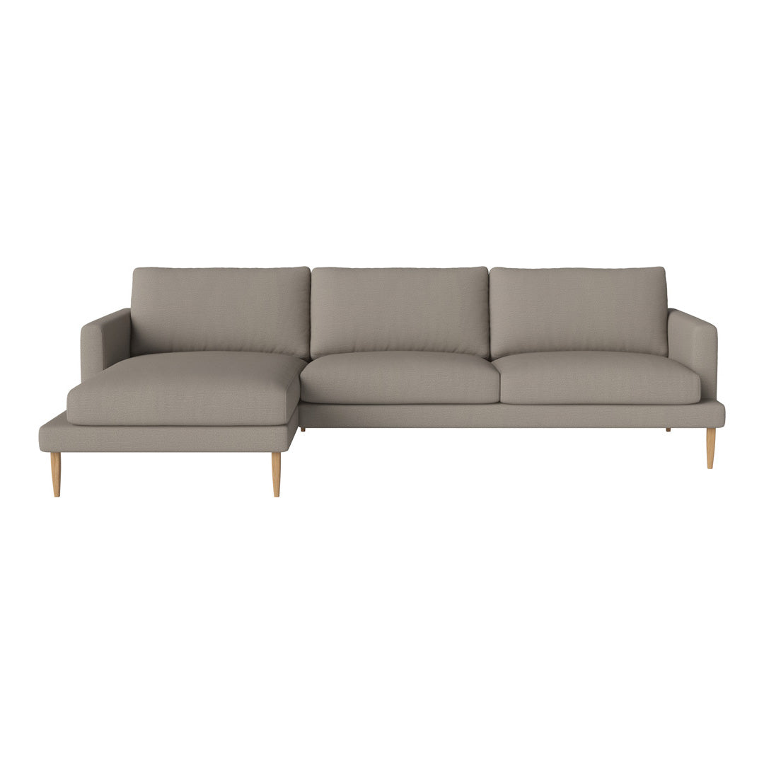 Modern L-shaped sofa in soft grey fabric with sleek wooden legs. Minimalist design with no patterns for a chic look.