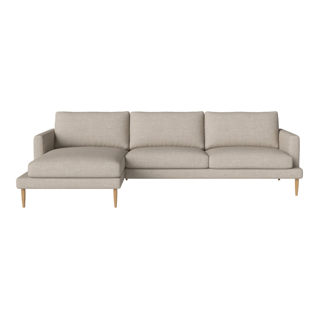 Light beige sectional sofa with solid color upholstery and wooden legs, featuring clean lines and modern design.