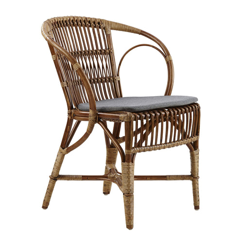 Stylish rattan chair in natural brown tones, featuring a sleek gray cushion and intricate woven patterns.