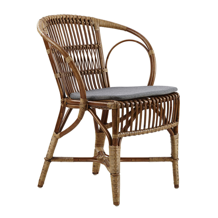 Stylish rattan chair in natural brown tones, featuring a sleek gray cushion and intricate woven patterns.