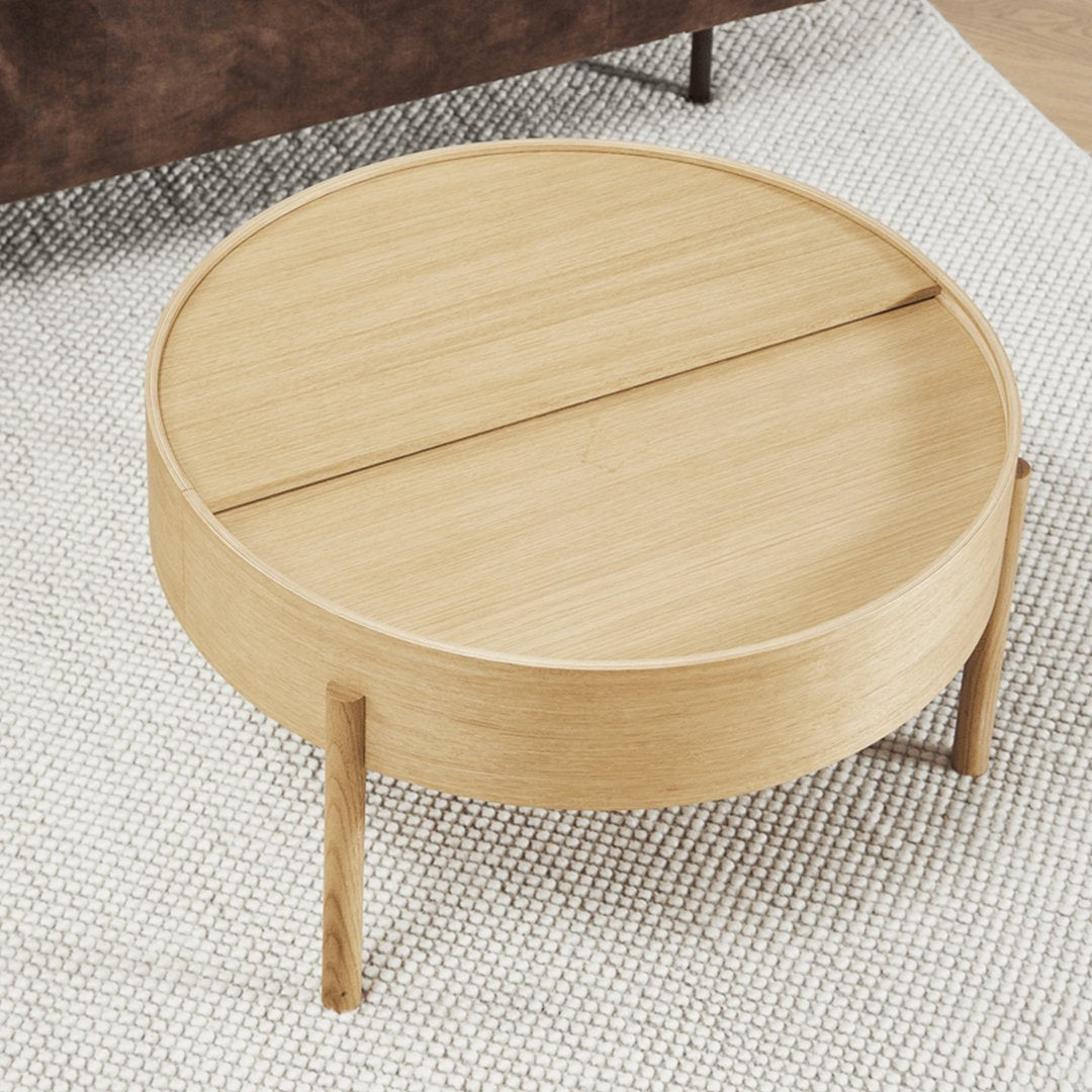 Round wooden coffee table with a light oak finish, featuring a smooth surface and minimalist design.
