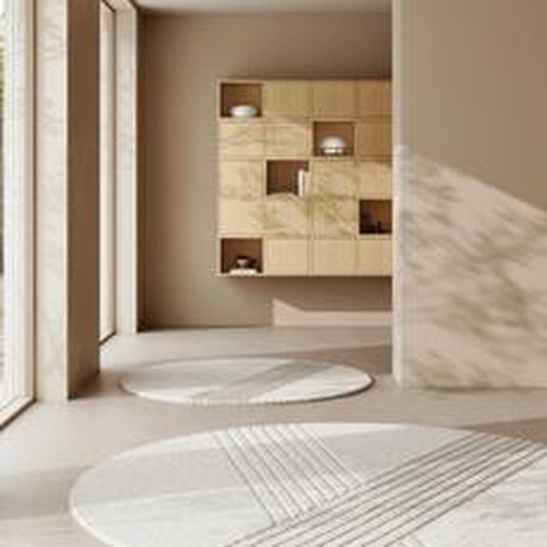 Round white rugs with geometric patterns in a modern, light-filled room featuring neutral beige walls and wood accents.