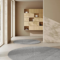 Gray round rugs with textured geometric patterns in a modern, minimalist living space. Neutral tones create a calming vibe.