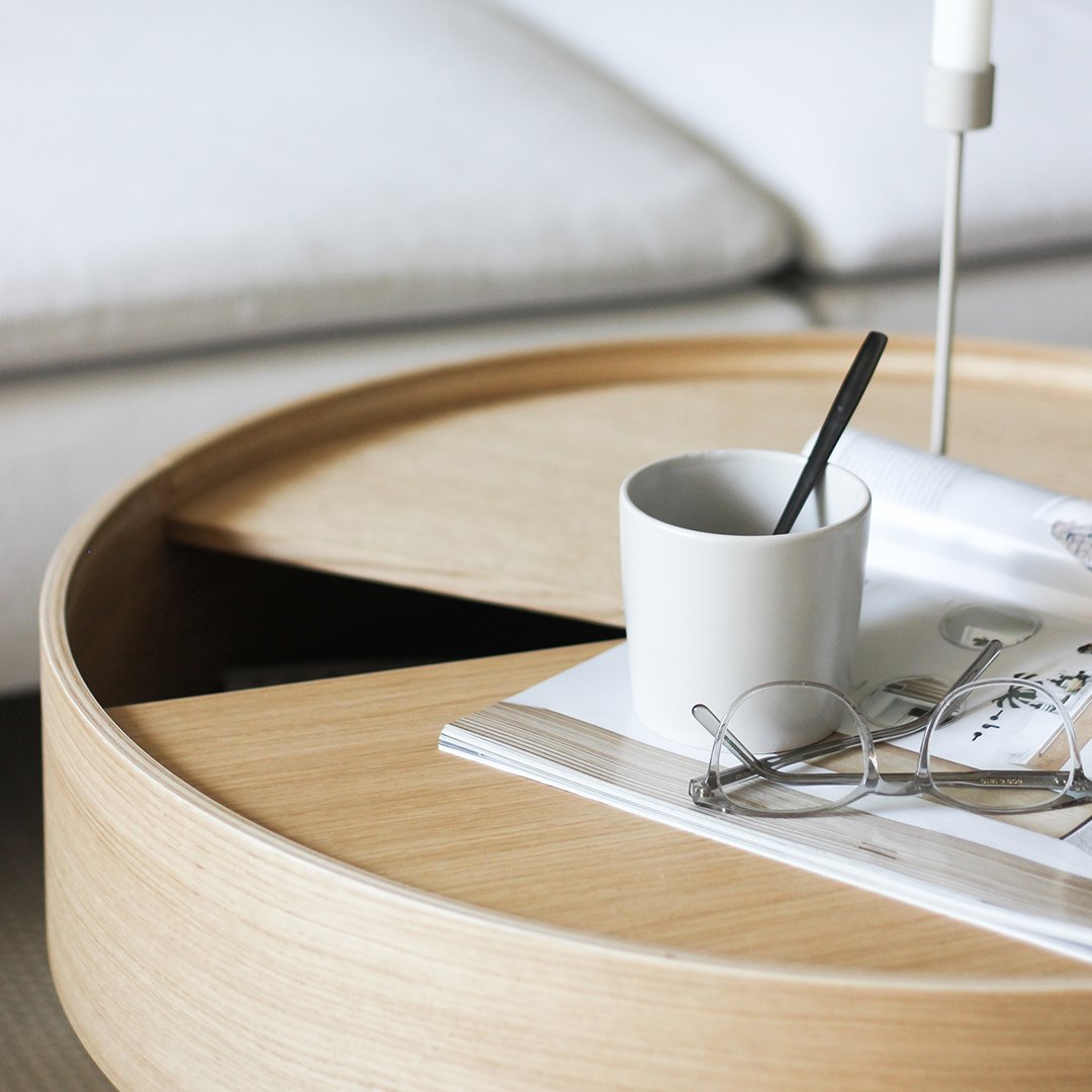 Natural wood round coffee table with light beige tones and smooth, clean lines, featuring a minimalist design.