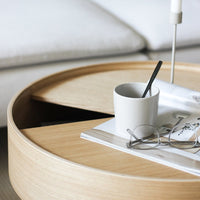 Natural wood round coffee table with light beige tones and smooth, clean lines, featuring a minimalist design.