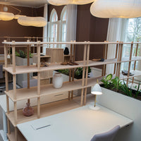 Light wood shelving unit with minimalist design, featuring soft neutrals and natural textures, perfect for modern spaces.