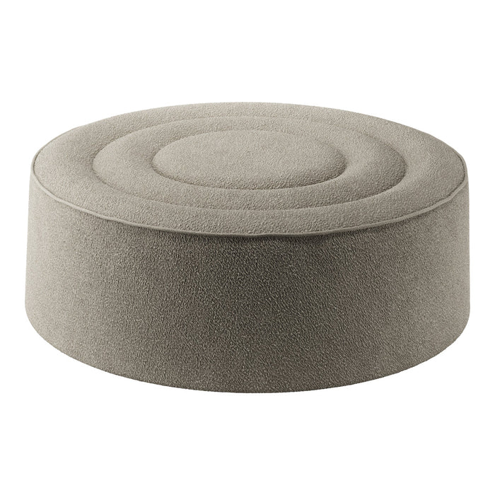 Round gray pouf with a textured, circular pattern on the top, perfect for modern decor.