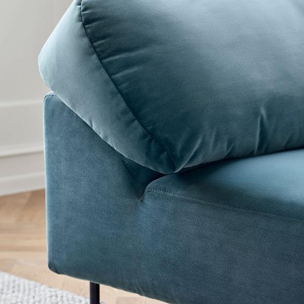 Teal velvet sofa corner with plush cushion and sleek, modern design, featuring a soft, matte texture.