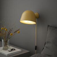 Yellow wall lamp with a sleek design, set against a soft gray wall, featuring neutral bedding and textured decor.