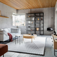 Modern living room featuring a mix of neutral tones, warm wood accents, and geometric patterns in furnishings.